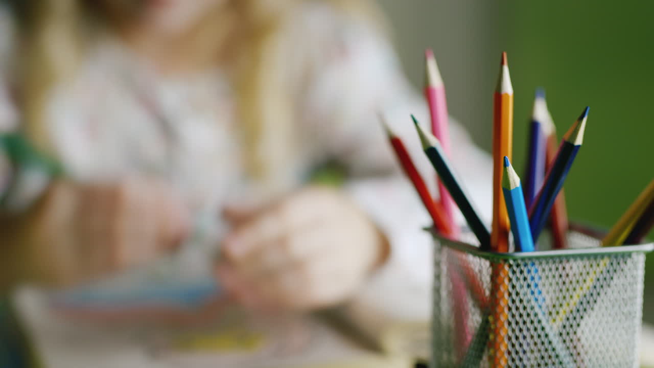 una niña está dibujando - en el marco solo hay manos visibles