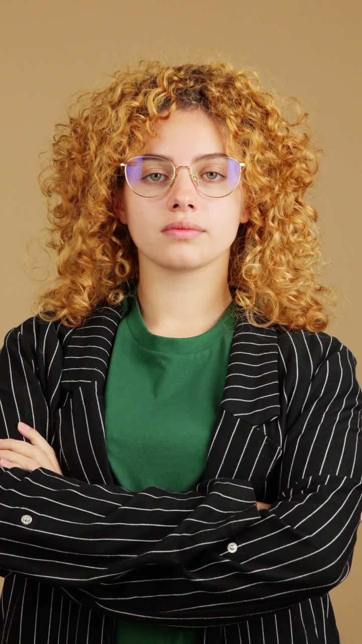 Portrait of a young woman with curly red hair and glasses
