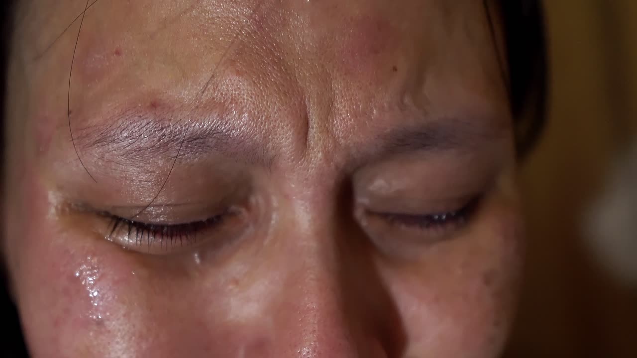 바람이 머리를 살짝 날리며 어두운 곳에서 지나치게 우는 여자의 극단적인 클로즈업