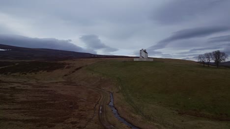volando hacia una encantadora iglesia blanca enclavada en las encantadoras tierras altas escocesas