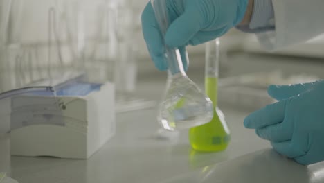 scientist handling chemical solutions in a laboratory setting