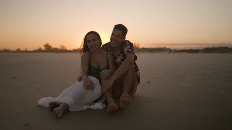 happy couple sitting on the sand