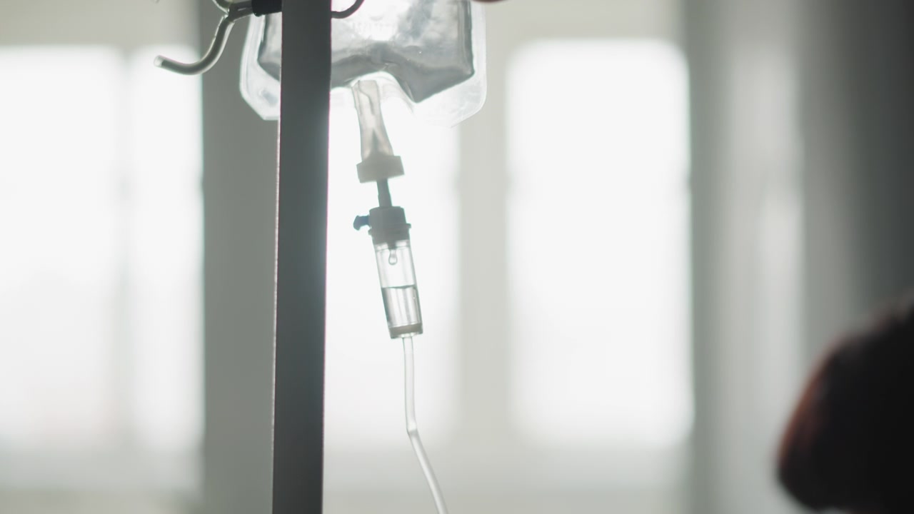 Scena medica calma. Ambiente domestico sereno durante un delicato processo di trattamento endovenoso. Tranquilla scena di infusione al capezzale che enfatizza il relax e l'atmosfera di recupero in un ambiente domestico
