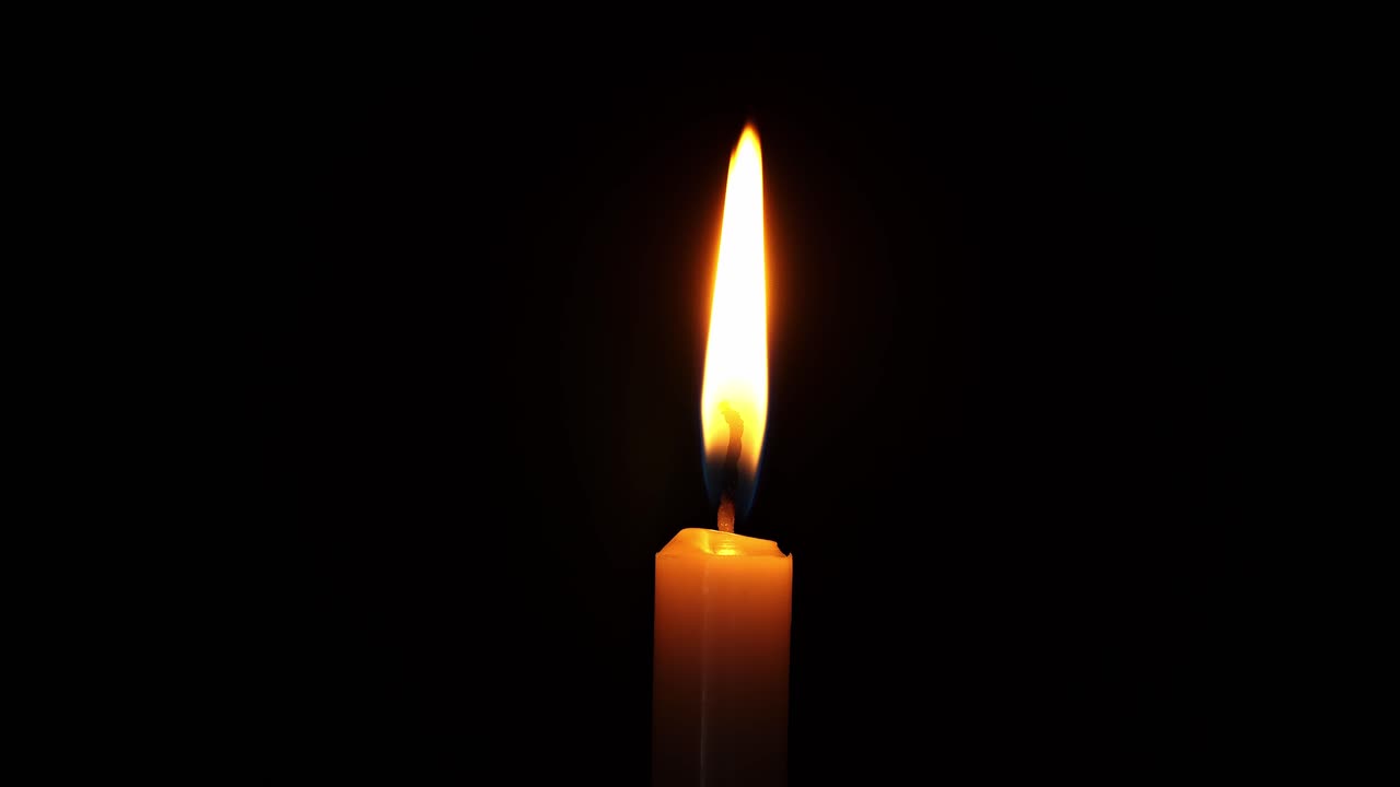 Bougie allumée, isolée sur un fond sombre