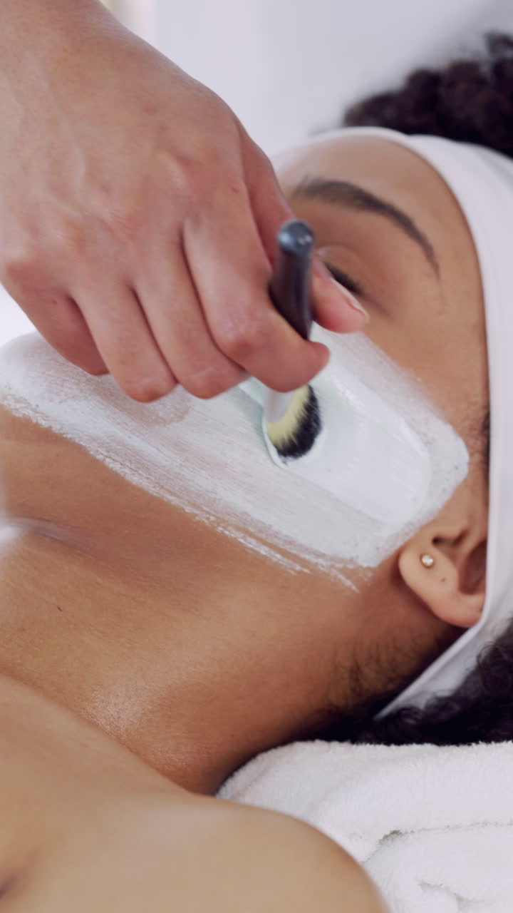 Donna che riceve un'applicazione di maschera facciale con pennello in una spa