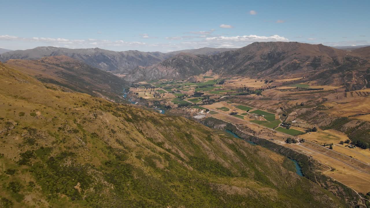 río azul y tierras de cultivo en un vasto valle rodeado de montañas escarpadas