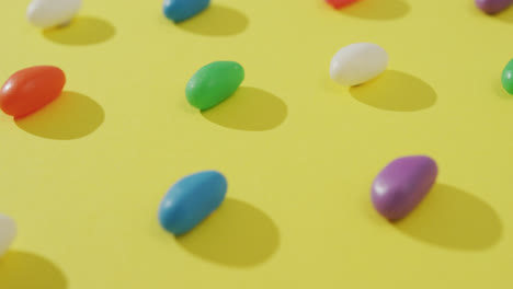 video de primer plano de filas de dulces multicolores sobre un fondo amarillo