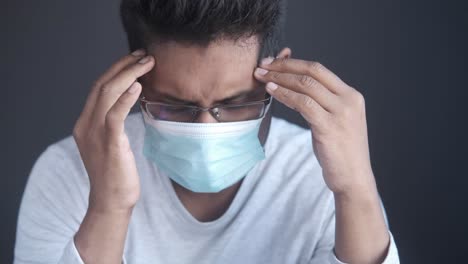 man with headache wearing a mask