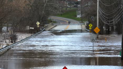 road closed sign and cones in front of a flooded street