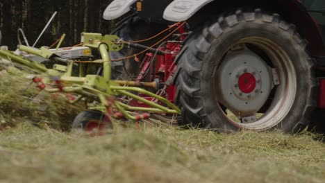 tracking shot of tractor tires passing through terrain while mowing grass