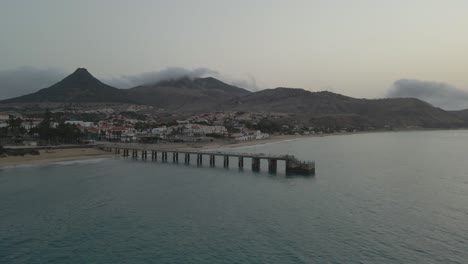 Drone-Panea-Sobre-Un-Muelle-Mientras-Las-Nubes-Grises-Ruedan-Sobre-Las-Montañas-En-La-Mañana