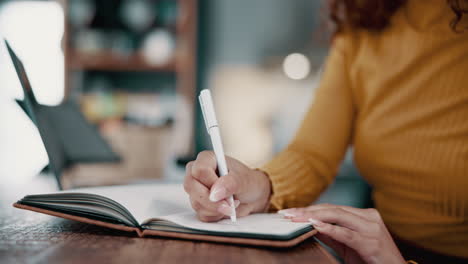 woman writing in notebook at desk