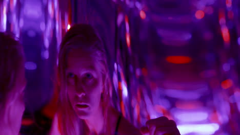 female dancer moving expressively in neon light through distorted reflections