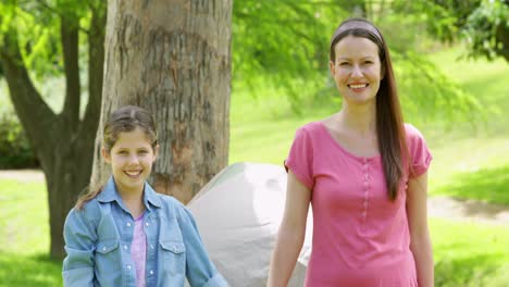 happy family on a camping trip with mother and daughter smiling at camera