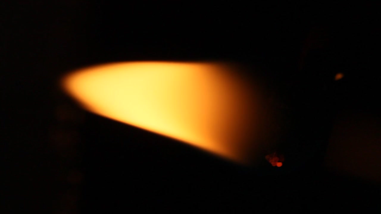 Lit candle flame on black background.