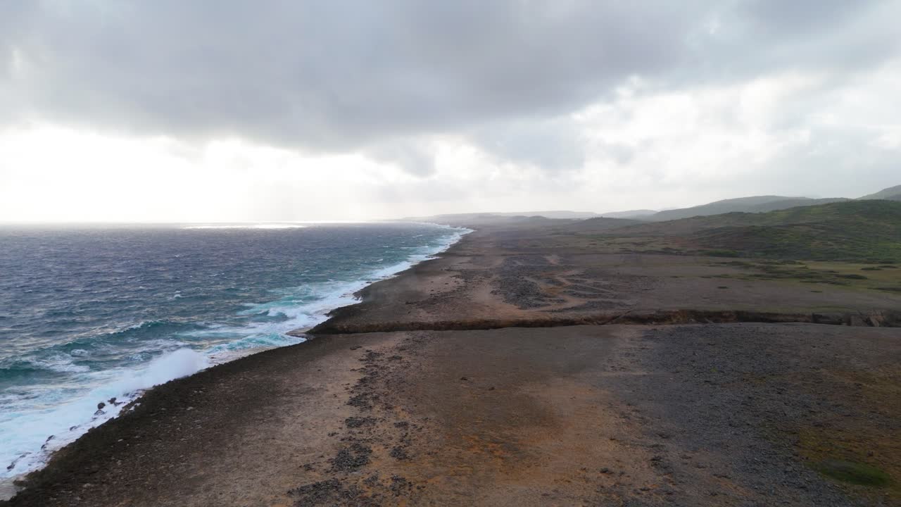 dolly aéreo panorámico por encima de las praderas saladas vacías y estériles con un canal de cala profunda en el campo de rocas del lado norte de la isla caribeña