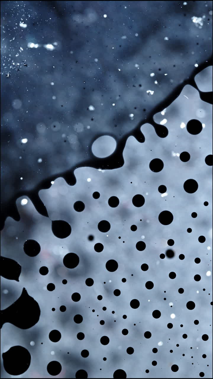 Liquidi bianchi e neri si fondono in un'ipnotica macro verticale