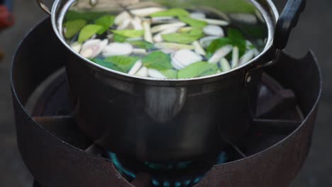 fresh ingredients of tom yam kung soup put on a simple stove top for boiling