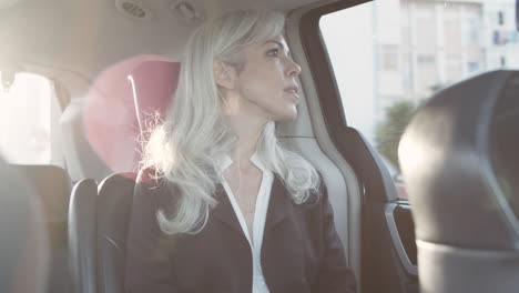 gray haired women sitting in backseat of moving car