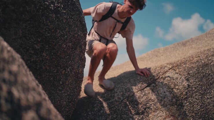 Tourist walking on large granite rocks in Koh Phangan low angle