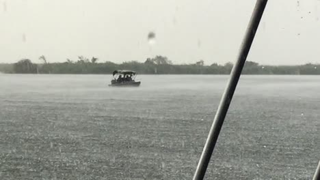 local fishermen brave a heavy rain storm on the chobe river, botswana