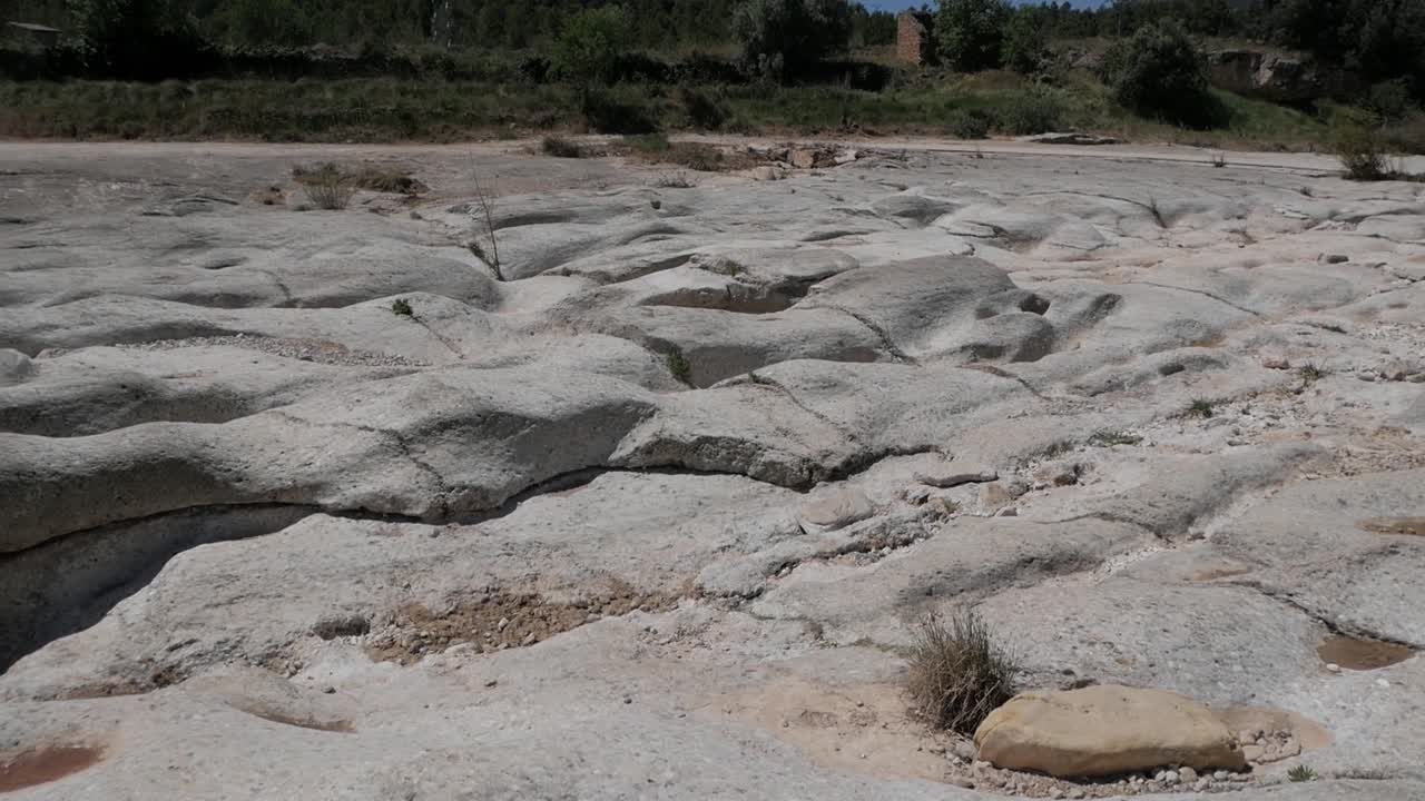 Eroded dry riverbed rock formations, Salt de la Portellada, summer, calm scene