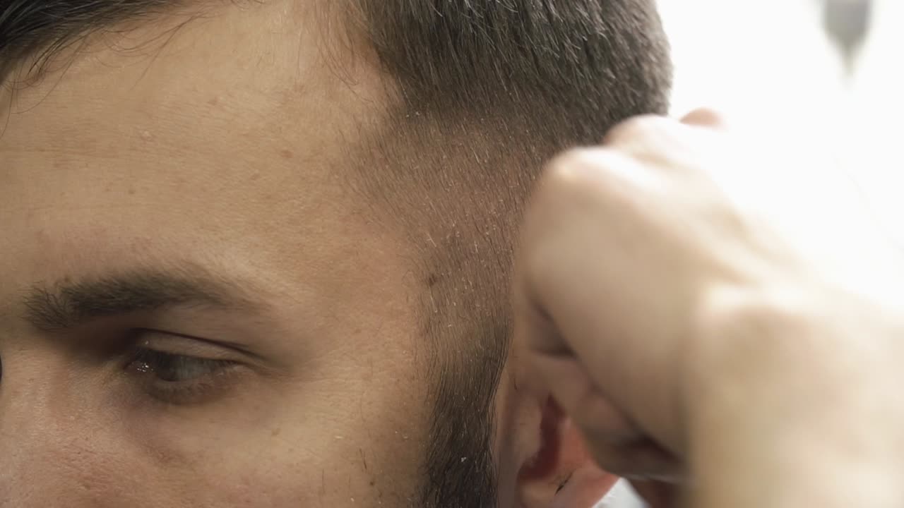 un hombre se corta el cabello en la barbería.