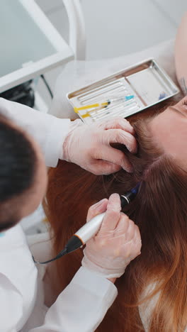 trichologist doing woman hair regeneration procedure dermapen microneedling vitamin injections