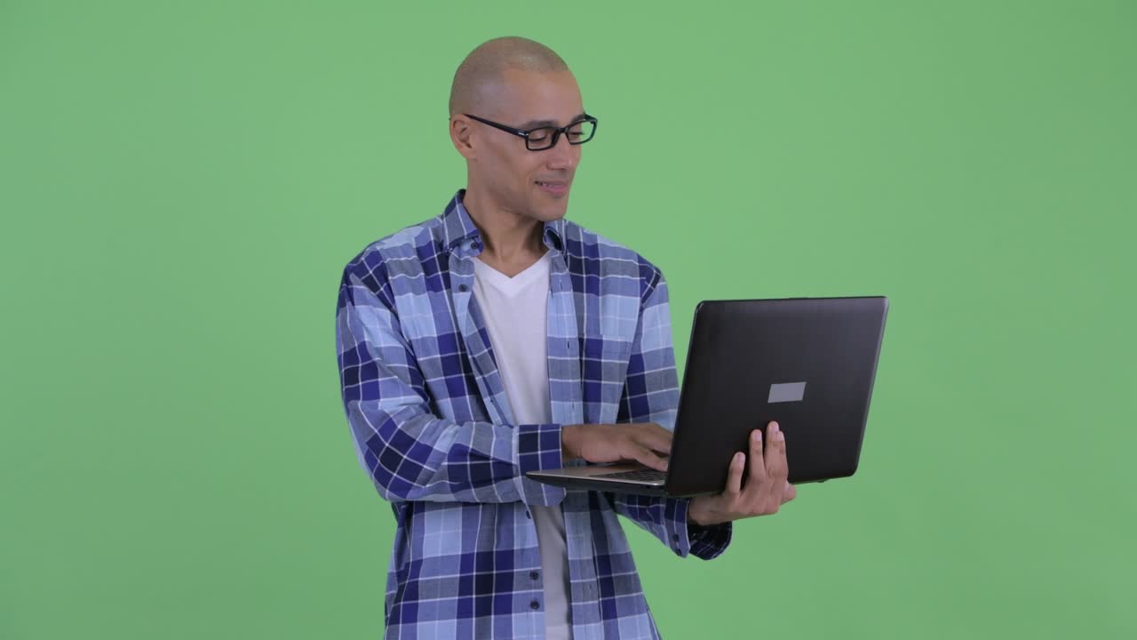 feliz hombre calvo hipster feliz pensando mientras usa la computadora portátil