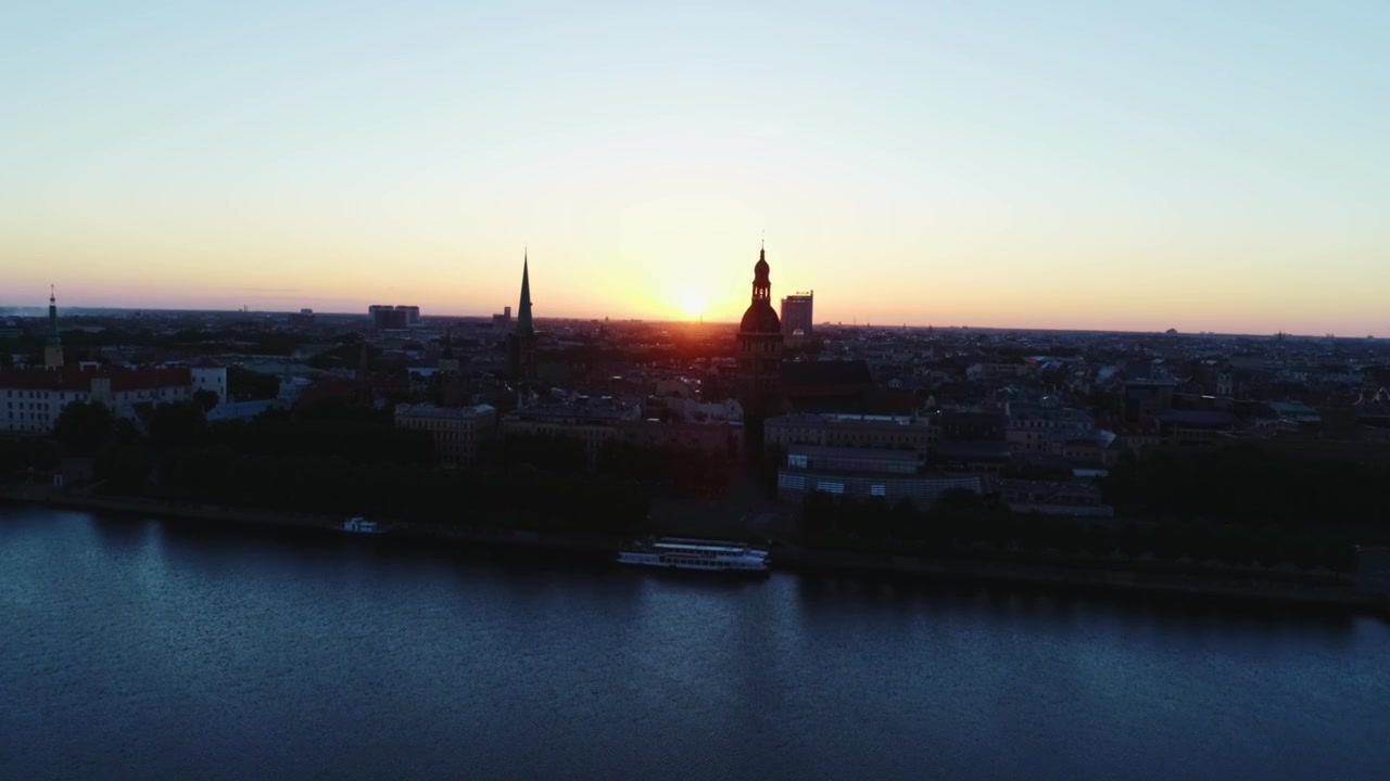 L'approccio aereo rivela lo skyline di Riga sagomato all'alba sul fiume Daugava
