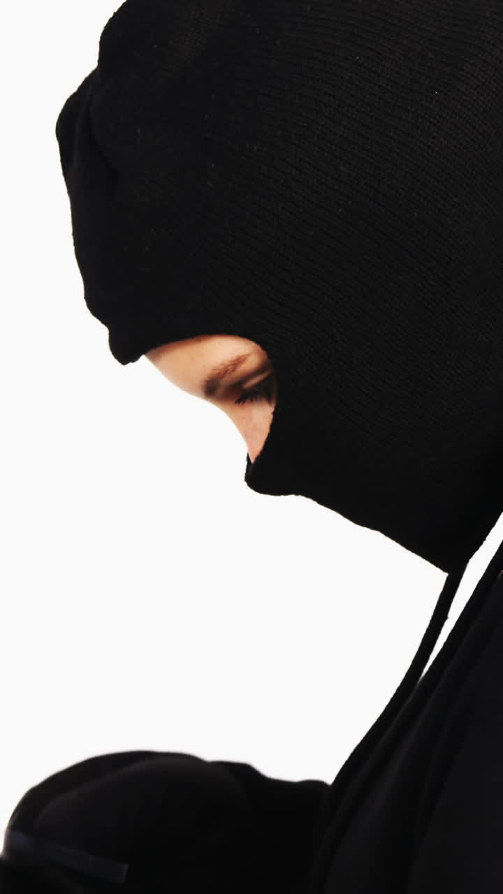 una ladrona haciendo compras en línea con una computadora portátil y una tarjeta de crédito