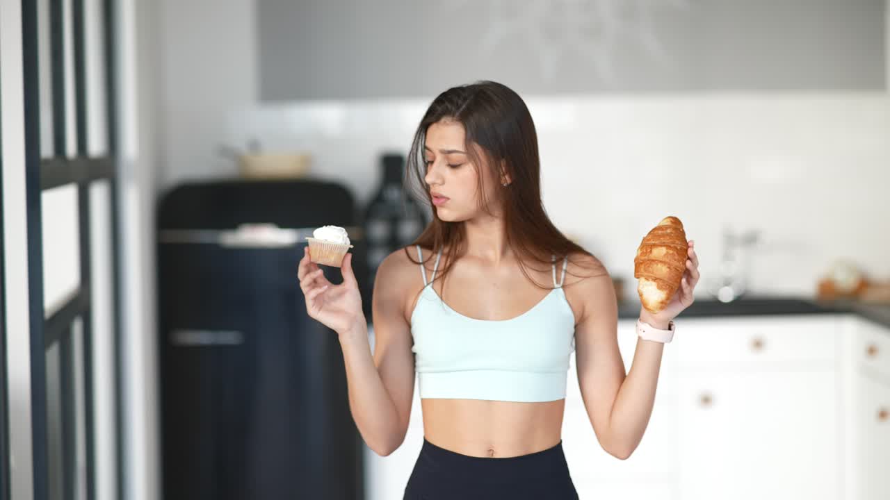 Donna che sceglie tra cupcake e croissant