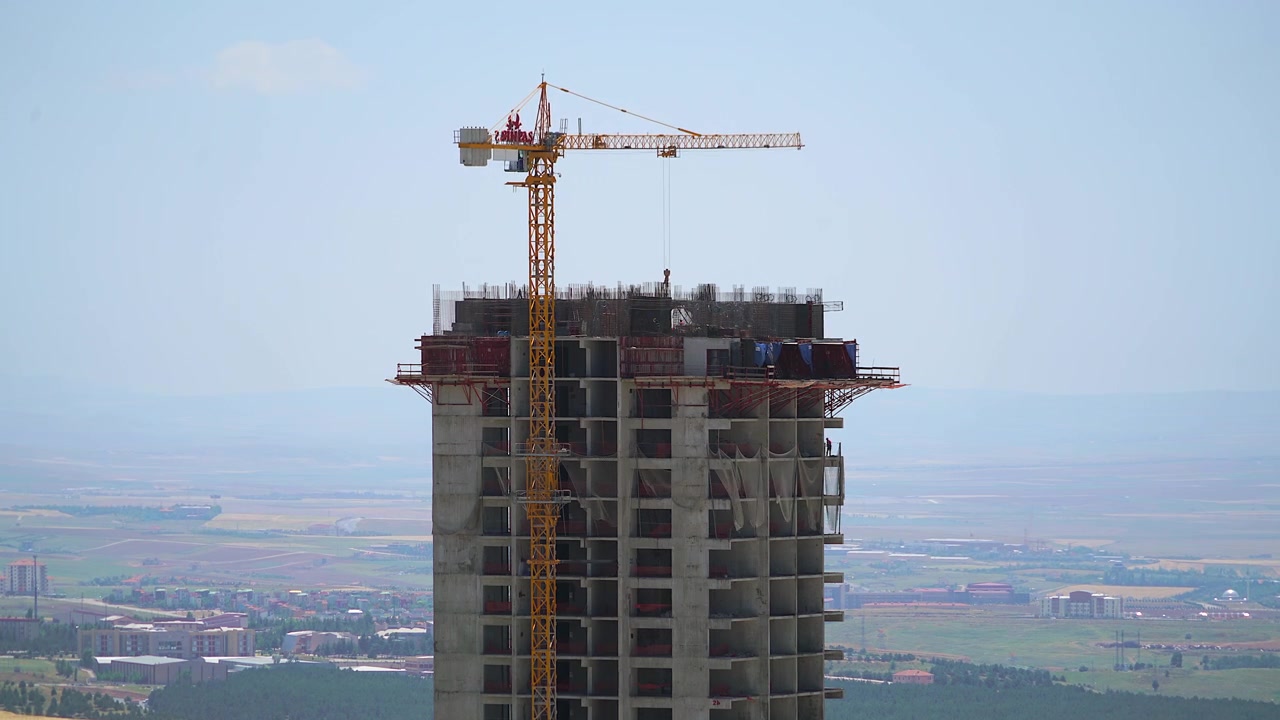 Grúa de construcción trabajando en la cima de un edificio de gran altura