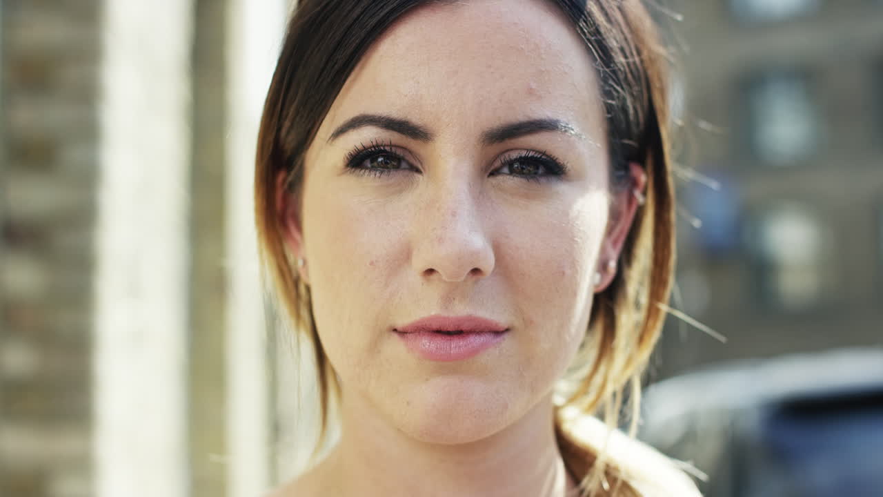 retrato de una mujer hermosa mirando a la cámara de fondo urbano en cámara lenta