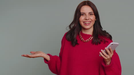 mujer sonriente mirando su teléfono