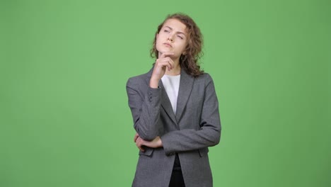 young beautiful businesswoman with curly blond hair thinking and looking up