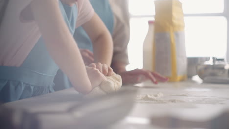 little girl and her mother are cooking domestic bread in sunday morning mom and daughter are kneading dough