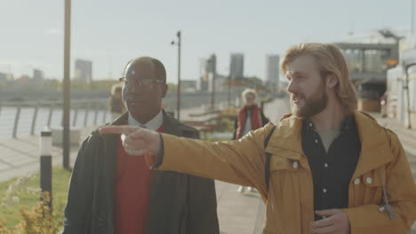 multiethnic friends walking in city and having talk