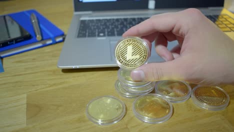 young professional business man in office holding up golden litecoin in his hands