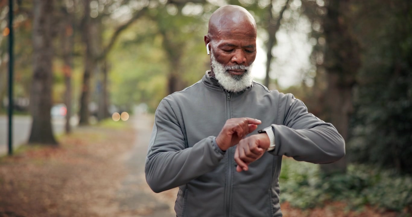 Senior Man Checking Smartwatch During Outdoor Run