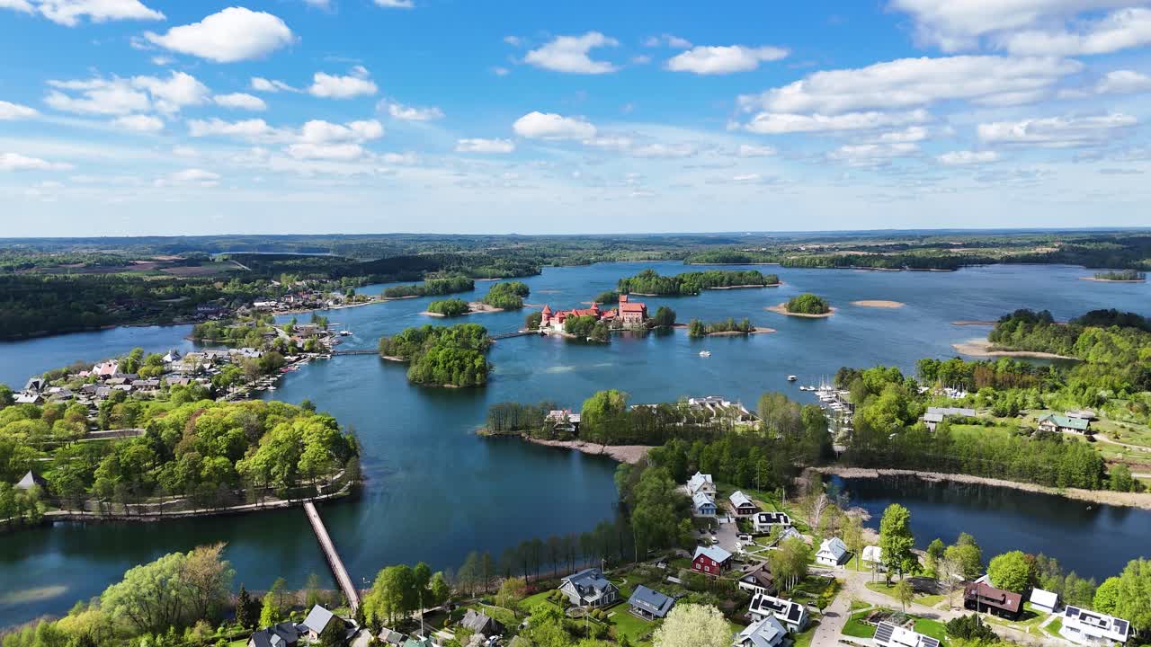 Vibrant township and Trakai island castle in Lithuania, aerial orbit wide angle view