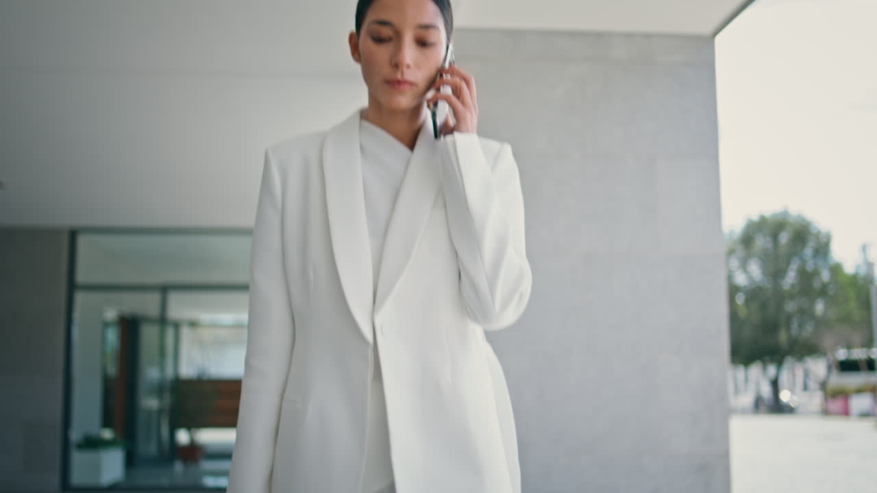 Stylish ceo calling walking city building in suit close up. Woman talking phone.