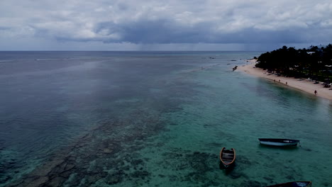 Slow-aerial-flight-above-crystal-clear-indian-ocean-beside-amazing-golden-beach