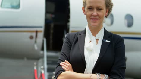 flight attendant standing with arms crossed on a runway 4k