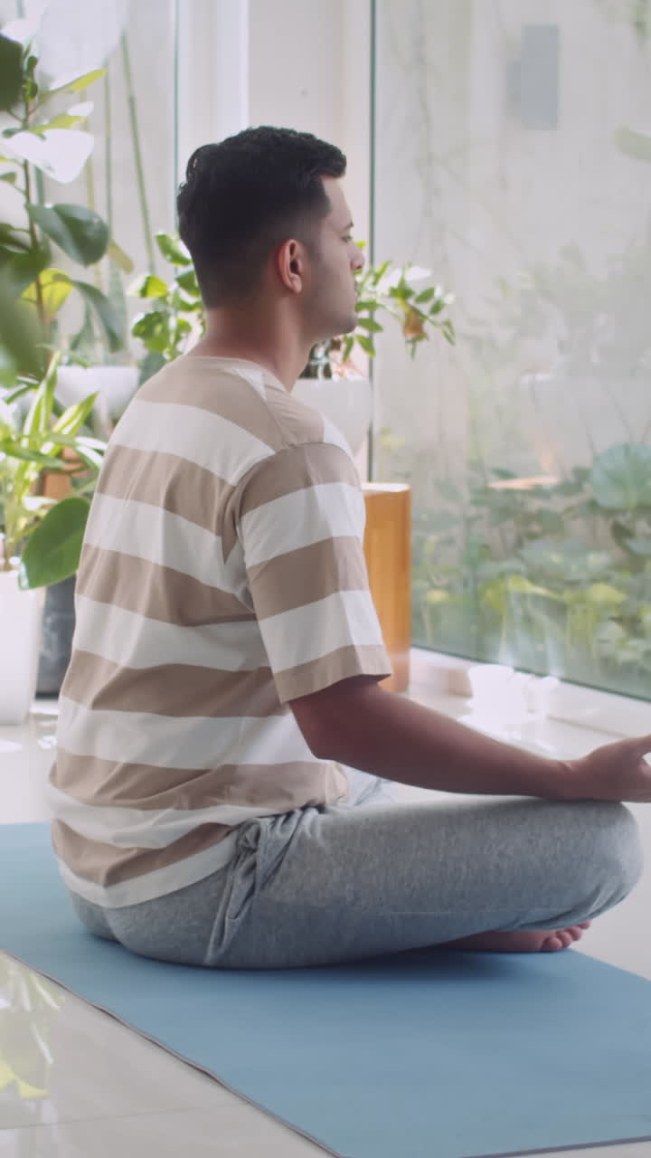Indian Man Practicing Lotus Pose Meditating at Home