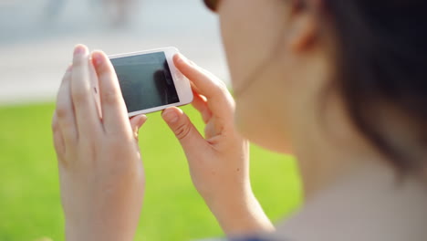 Frau-Video-Messaging-Handy-Im-Stadtpark-Handy-Im-Stadtpark