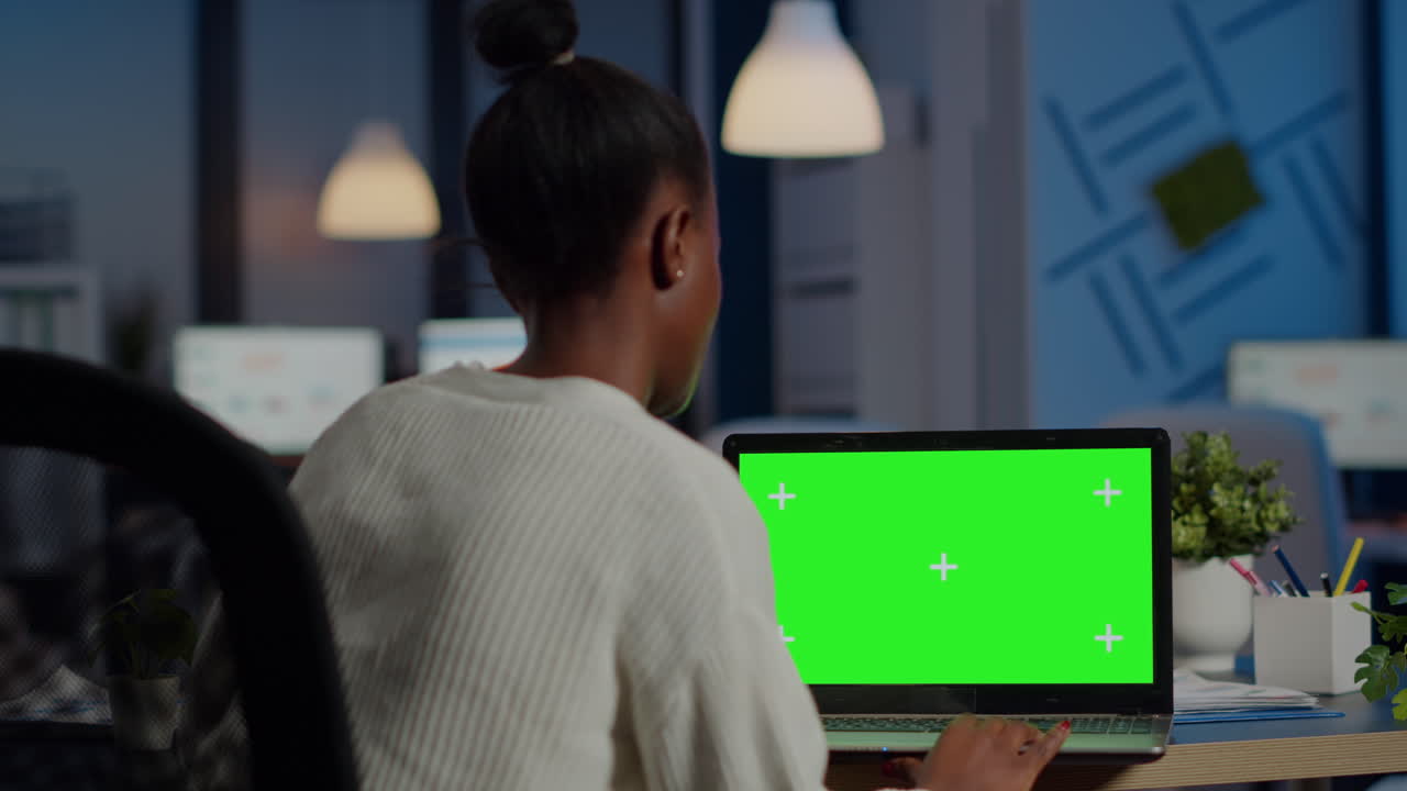 그린스크린 디스플레이 앞에서 일하는 검은 피부 프리랜서