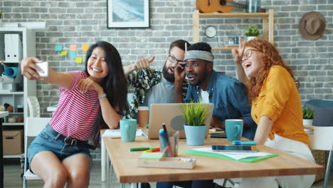 happy colleagues taking a selfie during a meeting