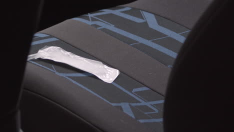 Hand-picks-up-loose-syringe-from-car-seat,-crime-scene