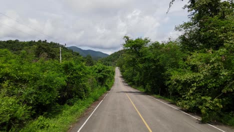 an aerial footage captured above the pavement leading to kaeng krachan national park, unesco world heritage site, thailand